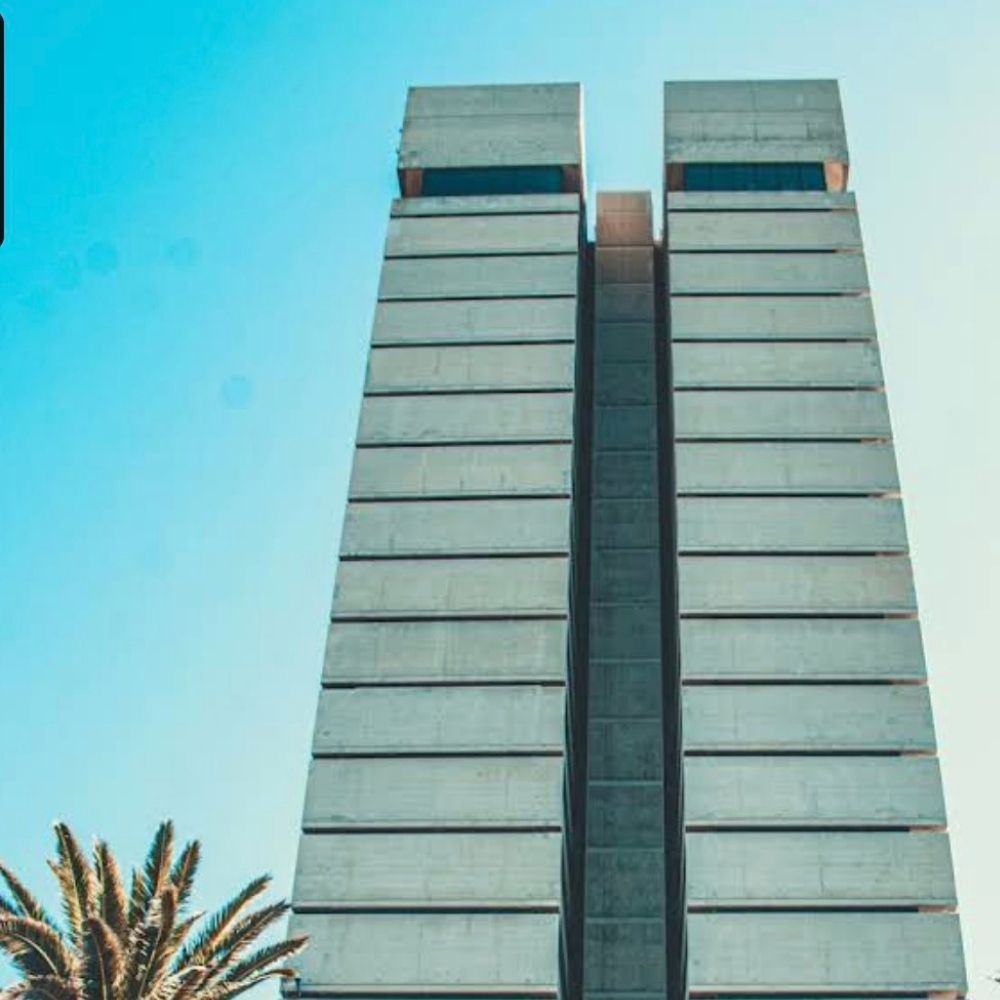 Nelson Mandela University Tower Building Facade Nelson Mandela University's twin tower building viewed from below against a clear blue sky.