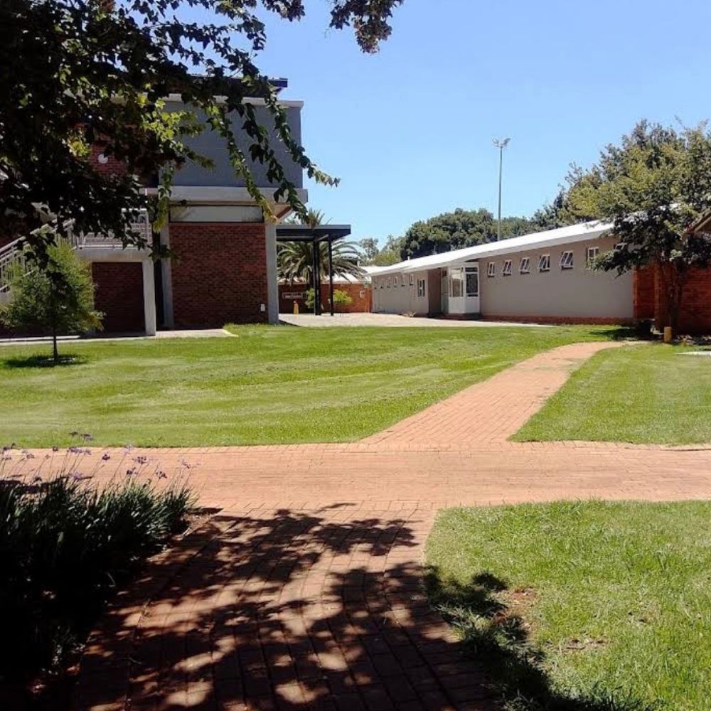 North-West University Campus Walkway and Lawn A brick pathway winding through a green lawn between buildings at North-West University.