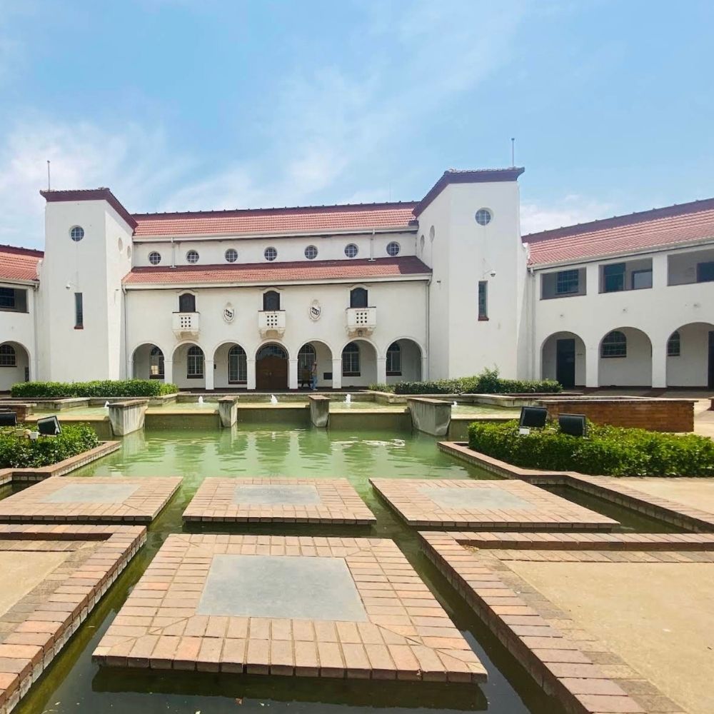 North-West University Fountain Courtyard Building North-West University's historic building with red-tiled roof and reflecting fountain pool in the courtyard.