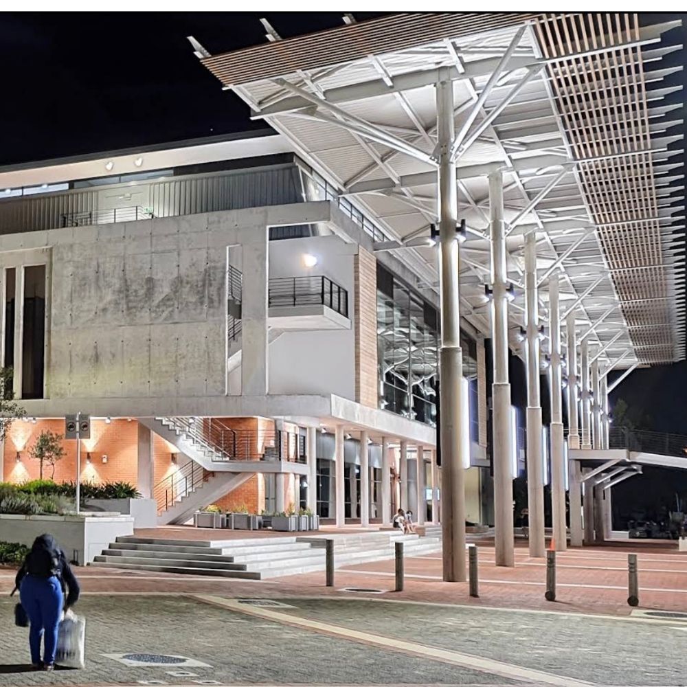 Modern Building at Night at Stellenbosch University A modern building with a large angled canopy roof is lit up at night at Stellenbosch University.