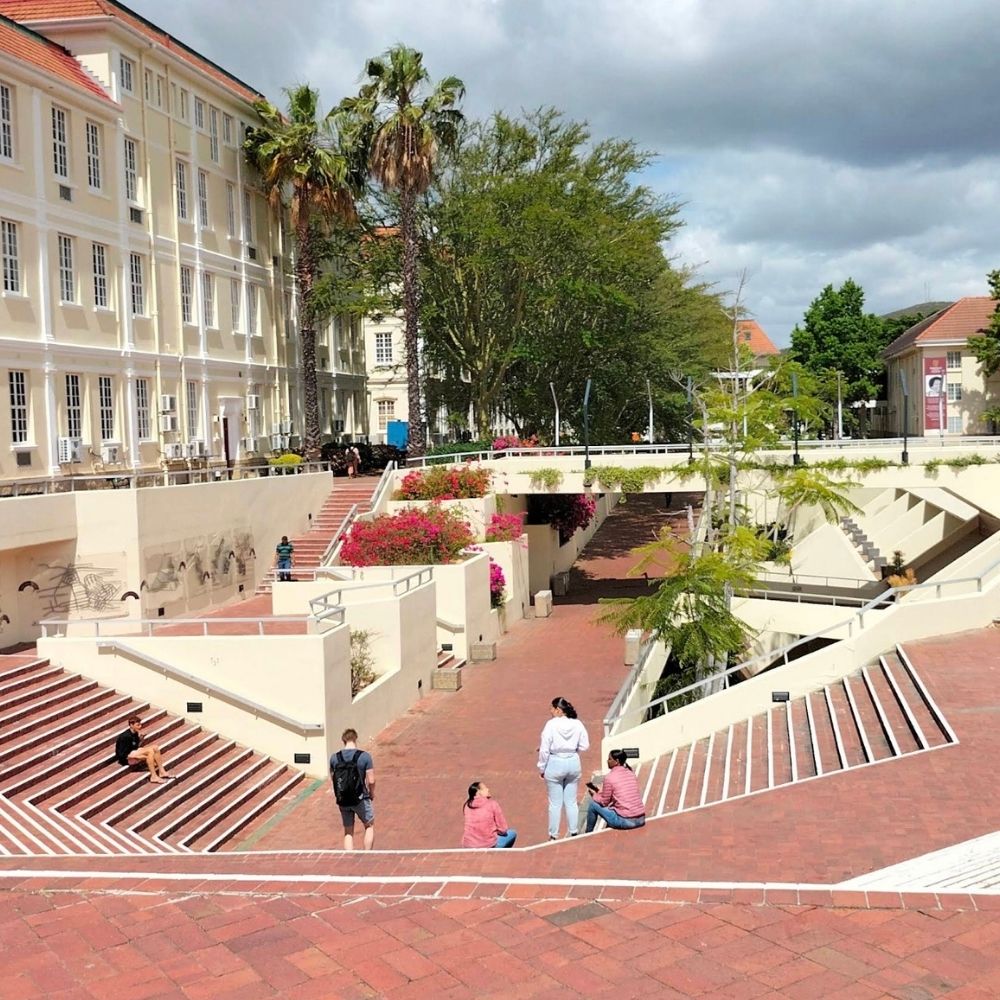 Stepped Plaza Terraces at Stellenbosch University Students sit and walk on the red brick stepped terraces of a plaza lined with palm trees at Stellenbosch University.